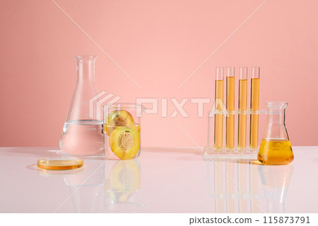 Designing template for peach extract product of cosmetic or beauty supplements. White table of laboratory containing erlenmeyer flask, test tube rack, beaker and petri dish, blank space for designing Designing template for peach extract product of cosmetic or beauty supplements. White table of laboratory containing erlenmeyer flask, test tube rack, beaker and petri dish, blank space for designing 115873791