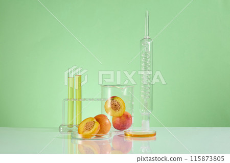 In the center of advertising photo is some experiment glassware including lab condenser, beaker, test tube in rack and petri dish containing a few peaches. Photo has front angle and space for text 115873805