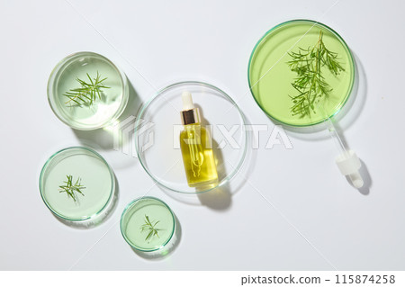 Empty label bottle of yellow liquid placed inside a large petri dish, displayed with other petri dishes against white background. Tea tree oil makes an ideal natural hand sanitizer Empty label bottle of yellow liquid placed inside a large petri dish, displayed with other petri dishes against white background. Tea tree oil makes an ideal natural hand sanitizer 115874258
