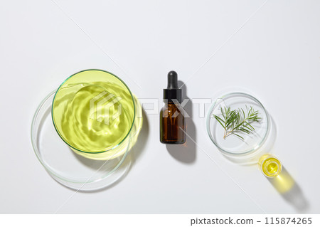 Natural and organic cosmetic concept with a glass serum bottle displayed with three petri dishes and a beaker of tea tree oil. Skincare concept with empty label Natural and organic cosmetic concept with a glass serum bottle displayed with three petri dishes and a beaker of tea tree oil. Skincare concept with empty label 115874265
