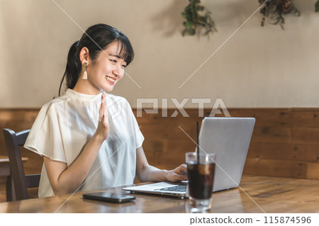 在咖啡館/共享辦公空間的網路會議/遠距會議期間，女商人揮手致意 115874596