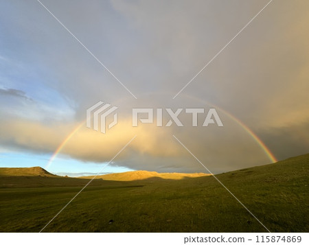 A rainbow over a grassland in the evening after a passing shower 1 A rainbow over a grassland in the evening after a passing shower 1 115874869