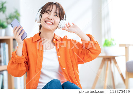 聽到與耳機的音樂的一個少婦 115875459
