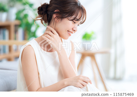 Young woman doing skin care in the living room Young woman doing skin care in the living room 115875469