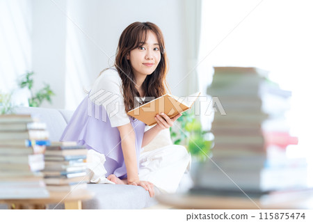 Young woman reading a book in the living room Young woman reading a book in the living room 115875474