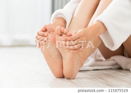 A young woman touching her feet. 115875529