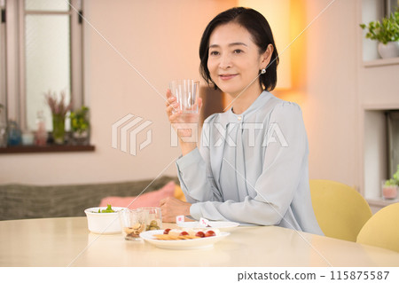 A middle-aged woman drinking beer with relish A middle-aged woman drinking beer with relish 115875587
