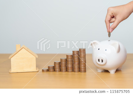 Money Saving, Property investment, House Mortgage and Real Estate Financial concepts. hand putting coin into piggy bank with Home model, Money stack Counting arrangement for deposit and Tax 115875705