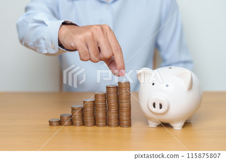 Money Saving for Future Plan, Retirement fund, Pension, Investment, Wealth Business and Financial concepts. hand putting coin into piggy bank on table, Money Counting and stack arrangement for deposit 115875807