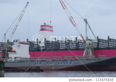 Cargo ship loading and unloading at a shipyard 115875838