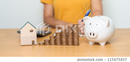 Money Saving, Property investment, House Mortgage and Real Estate Financial concepts. woman with coins stack piggy bank and Home model, Money stack Counting arrangement for deposit and Tax 115875857