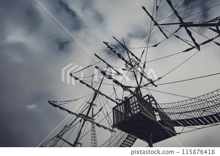 Looking up at the mast of a sailboat toy at night. A person points at a gondola. Looking up at the mast of a sailboat toy at night. A person points at a gondola. 115876418