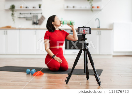 Woman recording fitness video at home in modern kitchen 115876723