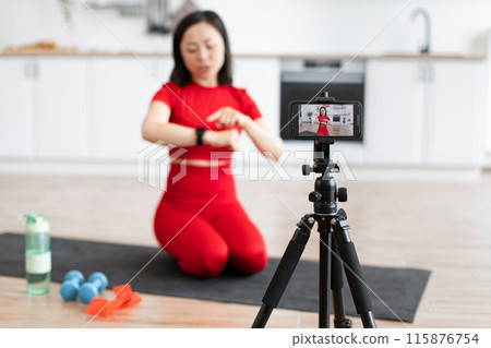 Sporty woman talks about smart watch during fitness vlog 115876754