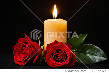 burning yellow candle and two red roses on a black background 115877374