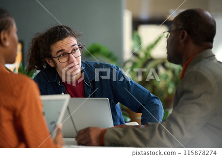 Portrait of gen Z young man collaborating with senior colleague in business meeting copy space Portrait of gen Z young man collaborating with senior colleague in business meeting copy space 115878274