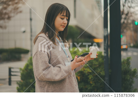A 20-something office lady having take-out coffee during her break 115878306