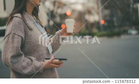 A 20-something office lady having take-out coffee during her break 115878312