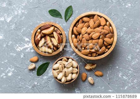 mixed nuts in wooden bowl. Mix of various nuts on colored background. pistachios, cashews, walnuts, hazelnuts, peanuts and brazil nuts mixed nuts in wooden bowl. Mix of various nuts on colored background. pistachios, cashews, walnuts, hazelnuts, peanuts and brazil nuts 115878689