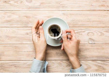 Minimalistic style woman hand holding a cup of coffee on Colored background. Flat lay, top view cappuccino cup. Empty place for text, copy space. Coffee addiction. Top view, flat lay Minimalistic style woman hand holding a cup of coffee on Colored background. Flat lay, top view cappuccino cup. Empty place for text, copy space. Coffee addiction. Top view, flat lay 115878732