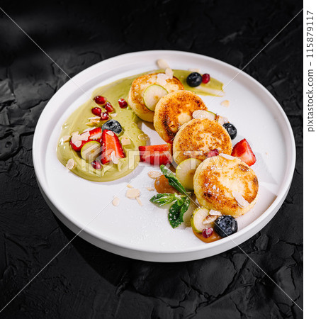 Gourmet cheese pancakes with fresh berries and sauce 115879117