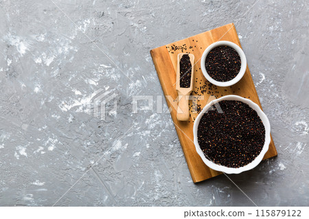 quinoa seeds in bowl and spoon on colored background. Healthy kinwa in small bowl. Healthy superfood quinoa seeds in bowl and spoon on colored background. Healthy kinwa in small bowl. Healthy superfood 115879122