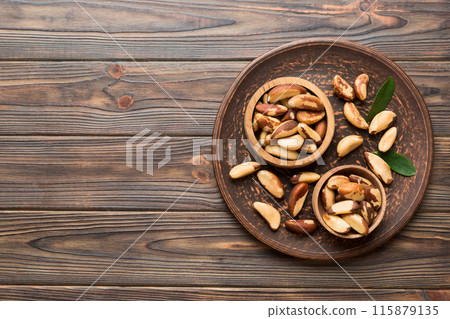 Fresh healthy Brazil nuts in bowl on colored table background. Top view Healthy eating bertholletia concept. Super foods Fresh healthy Brazil nuts in bowl on colored table background. Top view Healthy eating bertholletia concept. Super foods 115879135