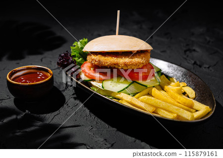 Gourmet chicken burger with fries on dark background Gourmet chicken burger with fries on dark background 115879161