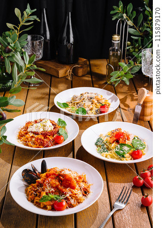 Assorted italian pasta dishes on wooden table 115879170