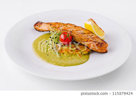 Gourmet grilled salmon on a bed of green sauce 115879424