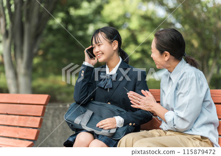 Female junior high school students and high school students in uniforms and blazers receiving good news over the phone, along with their mothers, teachers, and instructors 115879472