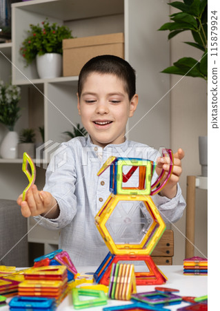 A child plays with a magnetic construction set. Interesting educational toys. 115879924