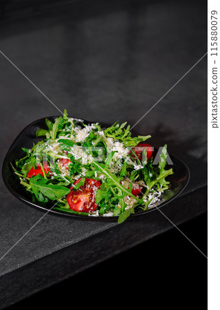 Fresh arugula and tomato salad with shaved parmesan 115880079