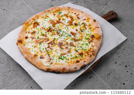 Freshly baked gourmet pizza on wooden board 115880112