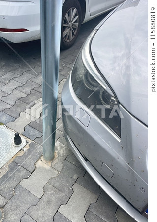 The part of the car that is parked close to the iron post The part of the car that is parked close to the iron post 115880819