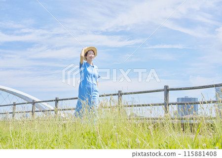 Portrait of a woman walking outdoors wearing a straw hat Portrait of a woman walking outdoors wearing a straw hat 115881408