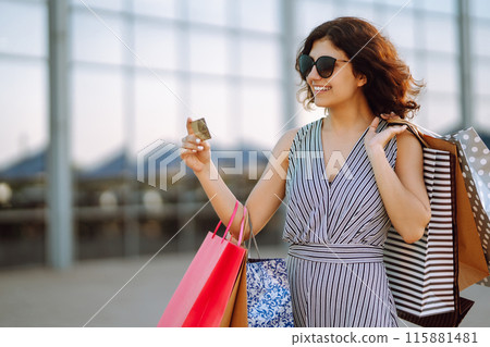Shopping time. Young woman with shopping bags near the mall. Consumerism, sale, purchases. 115881481