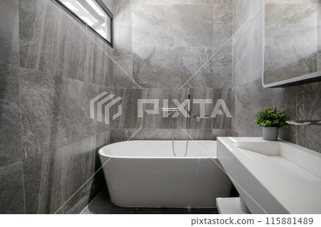 Black stone wall bathroom with white bathtub Black stone wall bathroom with white bathtub 115881489