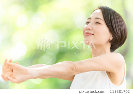 Middle-aged woman stretching fresh greenery Middle-aged woman stretching fresh greenery 115881702
