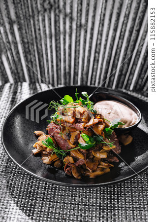 Gourmet fried mushrooms with beef steak and dip on elegant plate 115882153
