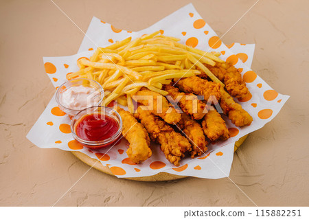 Crispy chicken tenders and fries with dips 115882251