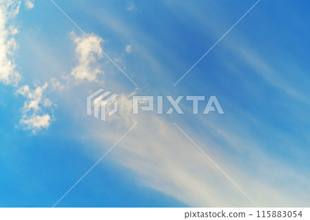 A developing plume of fine particles in the upper atmosphere with small clouds against a blue sky. Weather conditions 115883054