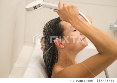 Dark-haired woman taking a shower and looking relaxed Dark-haired woman taking a shower and looking relaxed 115883755