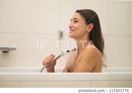 Cute woman sitting in the bathroom and having a shower Cute woman sitting in the bathroom and having a shower 115883776
