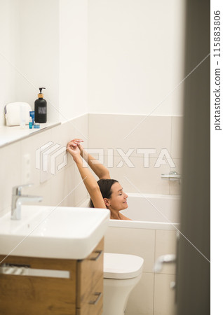 Dark-haired woman feeling relaxed in the bathroom Dark-haired woman feeling relaxed in the bathroom 115883806