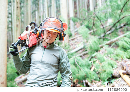 伐木完成後,一名攜帶電鋸的森林工人從一個伐木場移動到下一個伐木場。 伐木完成後,一名攜帶電鋸的森林工人從一個伐木場移動到下一個伐木場。 115884990