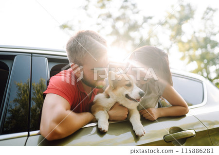 Lovely young couple with dog sits in back seat of car. Concept of active lifestyle, weekend, relax. 115886281