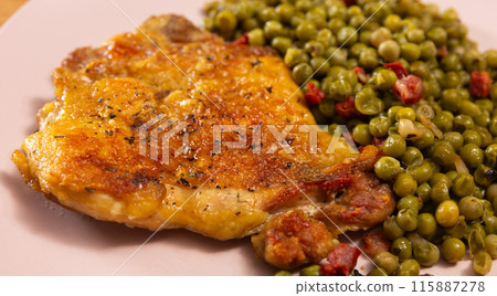 Delicious crispy chicken with peas as a side dish on a plate Delicious crispy chicken with peas as a side dish on a plate 115887278