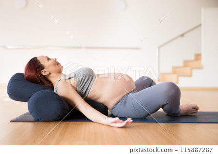 Pregnant woman is engaged in yoga. Reclined Bound Angle Pose or Supta Baddha Konasana Pregnant woman is engaged in yoga. Reclined Bound Angle Pose or Supta Baddha Konasana 115887287