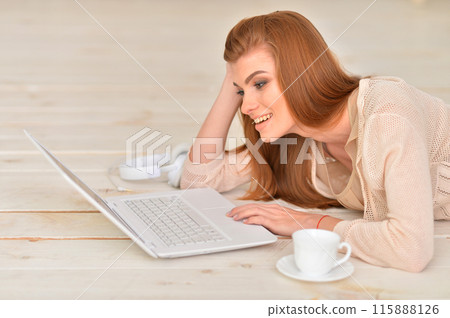 Adult beautiful woman lying on floor with laptop 115888126